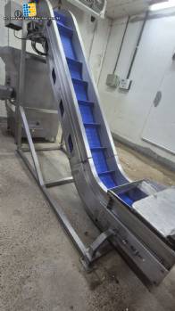 Cinta transportadora inclinada de acero inoxidable Inova Industrial con tacos.